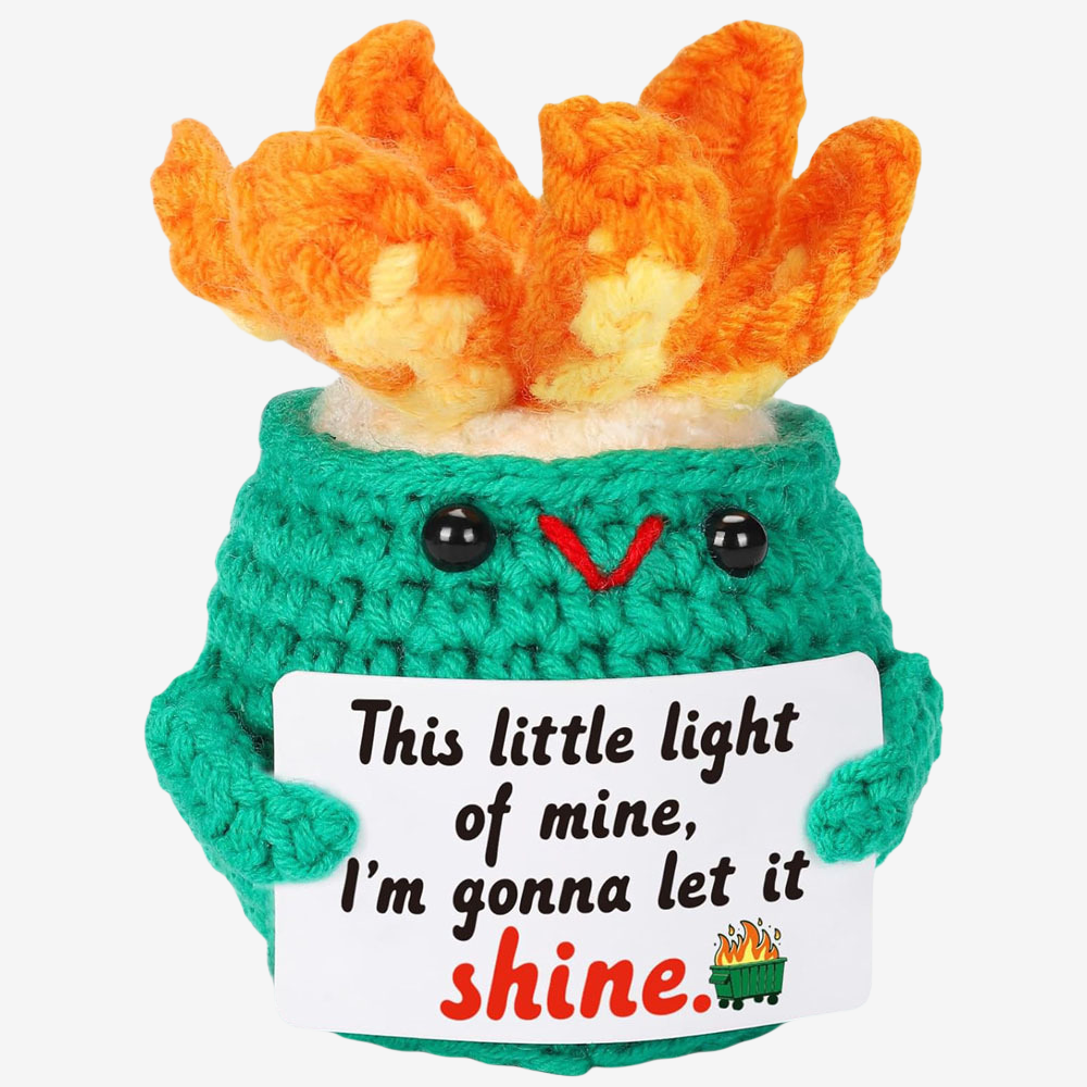 The ZoDoll Shine Bright Crochet Star Amigurumi features a green plush with orange flames and a sign saying "This little light of mine, I’m gonna let it shine"—an inspirational Glow Plush for hope and positivity.
