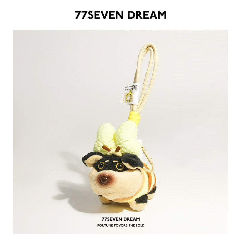 Plush dog charm with yellow bunny-ear-style headwear and striped body