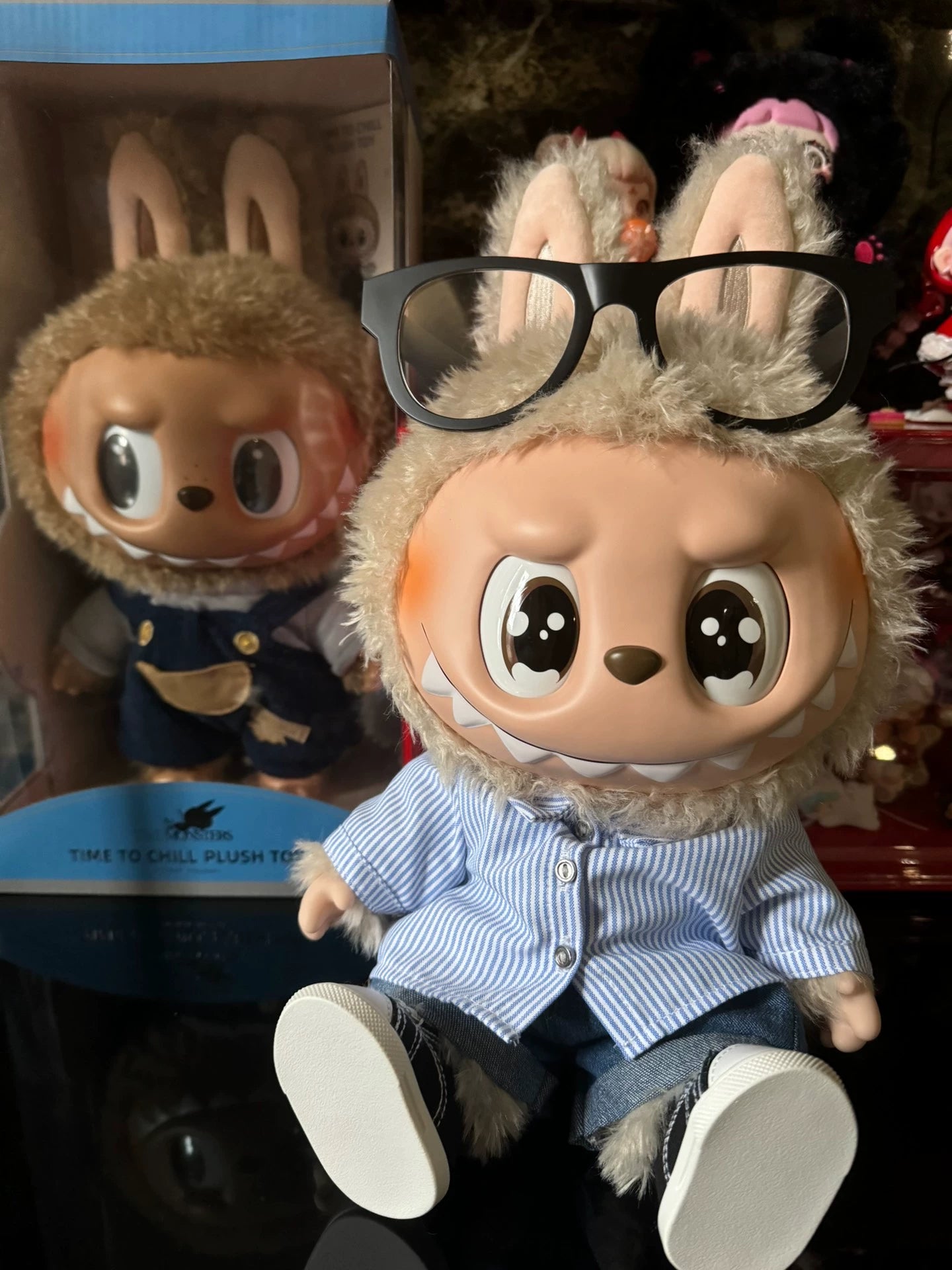 The POP MART THE MONSTERS – FLIP WITH ME 38cm Labubu Vinyl Plush Doll features bunny ears, glasses, a sailor shirt, and denim—an ideal collectible for fans of designer fashion art and vinyl dolls.