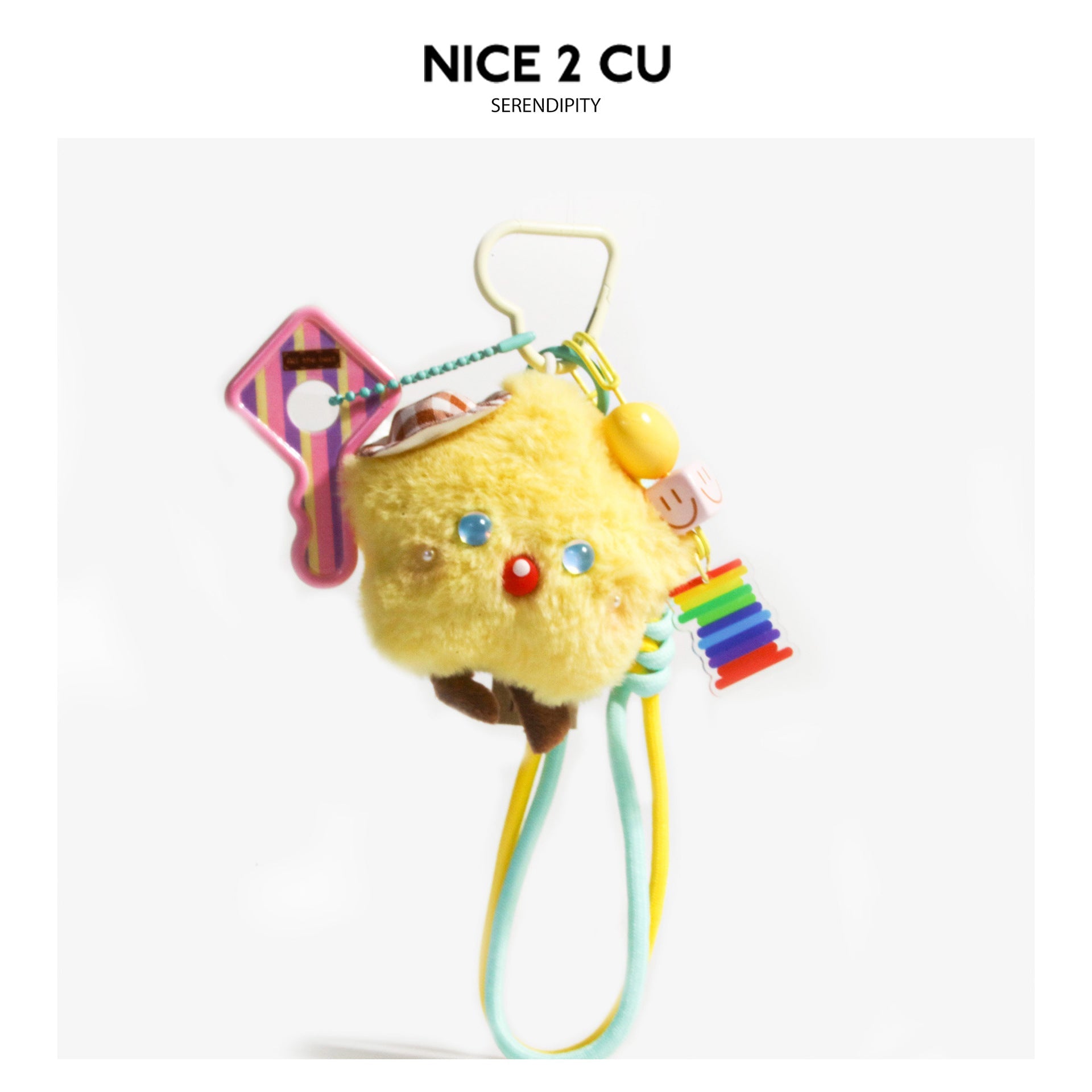 Yellow star-shaped plush bag charm with brown checkered hat, blue eyes, red nose, rainbow acrylic pendant, and mint-yellow lo