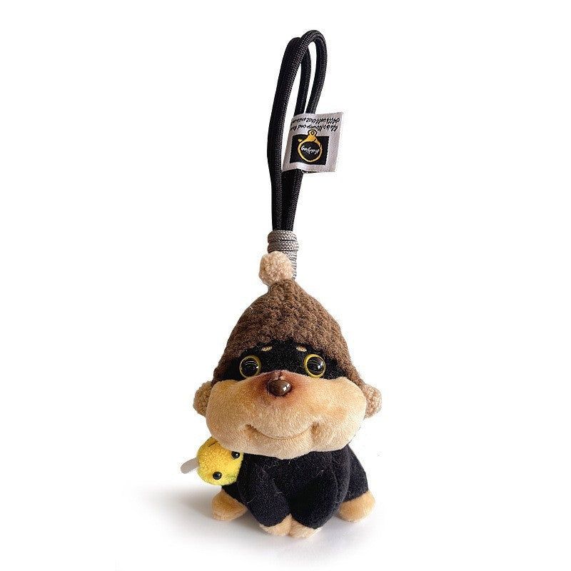 Plush dog keychain charm with dark brown hat and small bee decoration on the side