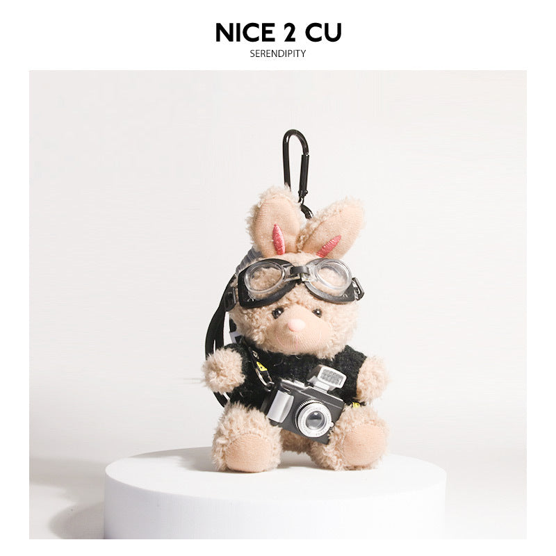 Brown plush rabbit keychain in black-and-white heart-pattern sweater with goggles and camera pendant
