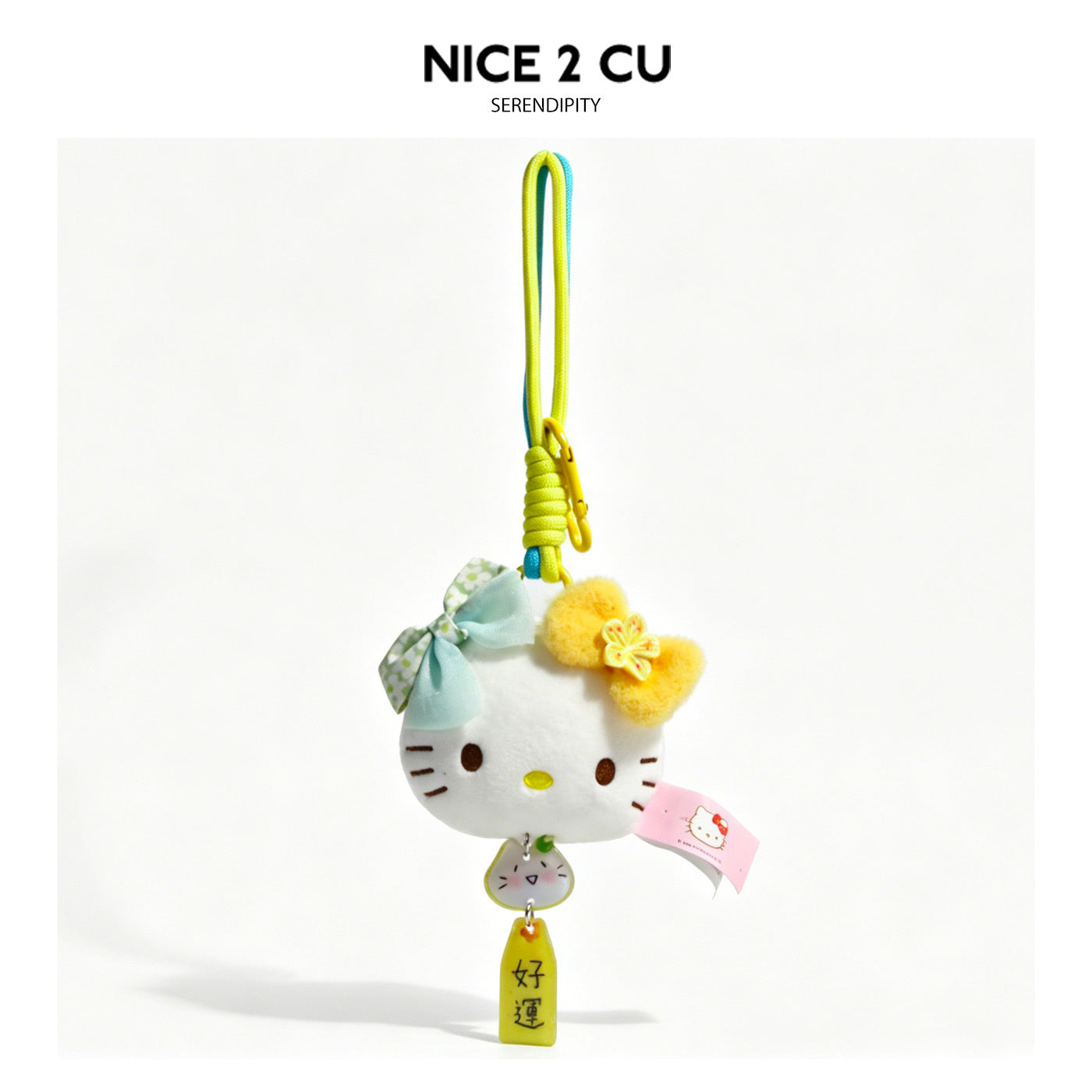 White kawaii cat-face plush charm with yellow bow, mint bow, dangling cat charm, and Good Luck tag on braided cord clip