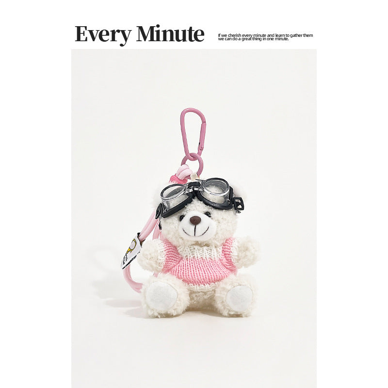 White bear plush keychain charm wearing aviator goggles and a pink-and-white knit sweater with pink carabiner clip