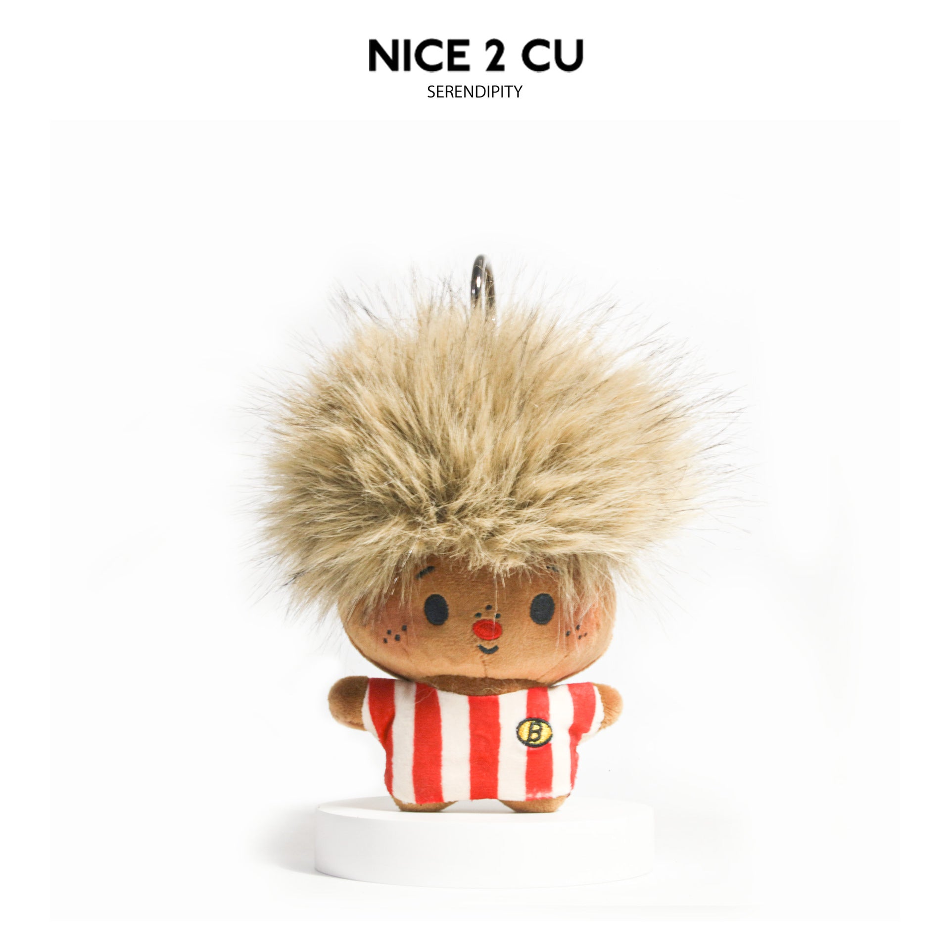 Golden blond fluffy afro plush charm in red-and-white striped outfit on white display stand