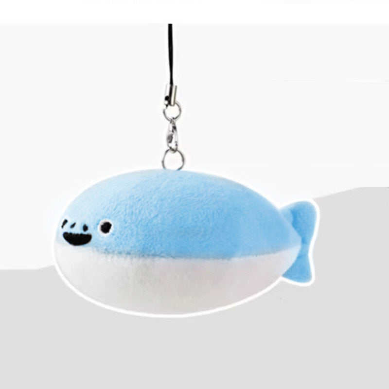 Light blue and white fish-shaped plush keychain with smiling embroidered face and black loop strap