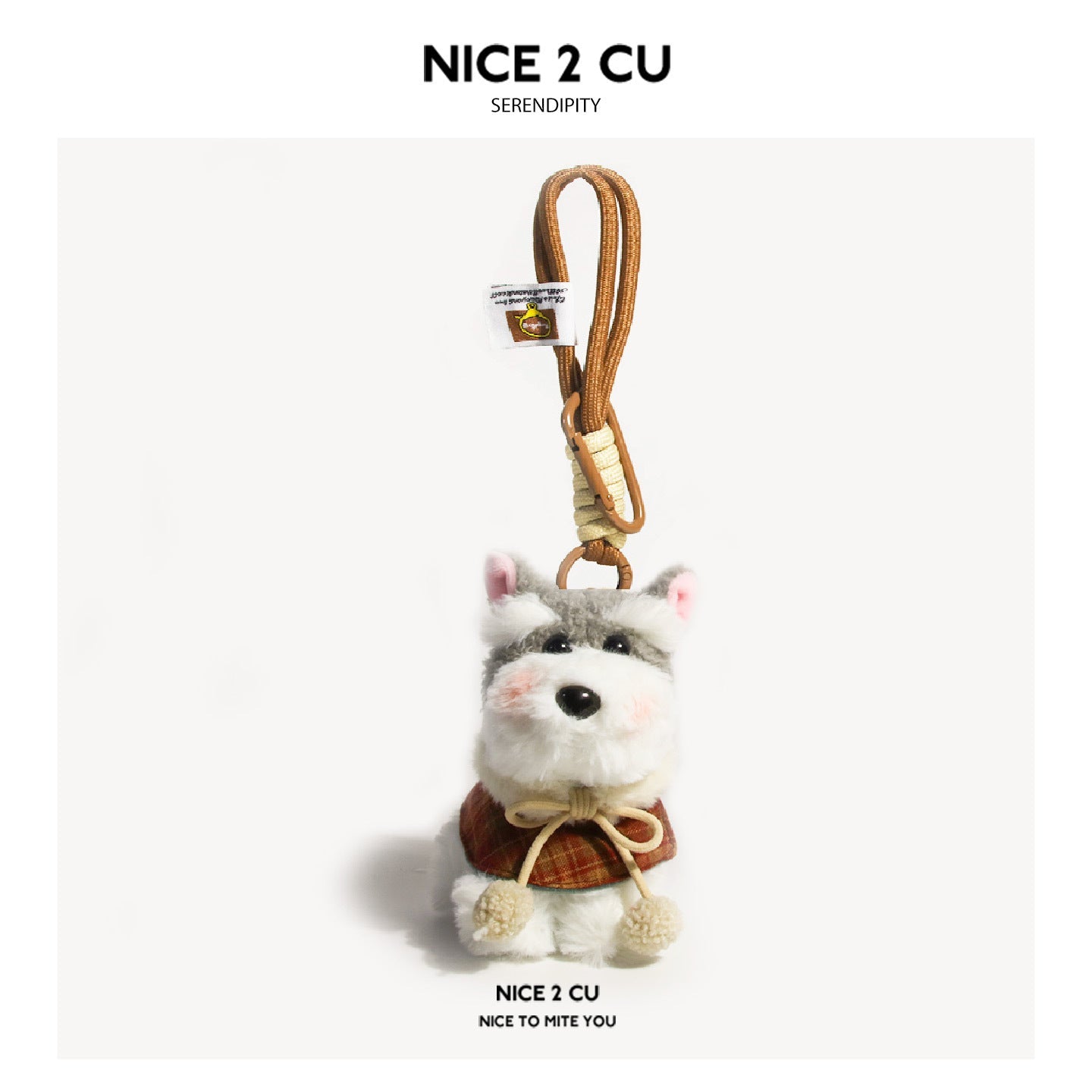 Schnauzer plush keychain charm wearing a rust-red plaid cape with cream pom-pom ties and braided brown clip lanyard