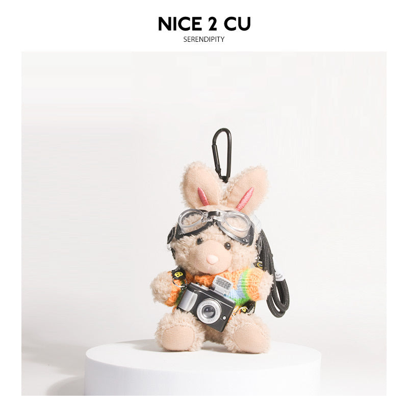 Brown plush rabbit keychain wearing rainbow-striped knit sweater with goggles and miniature camera