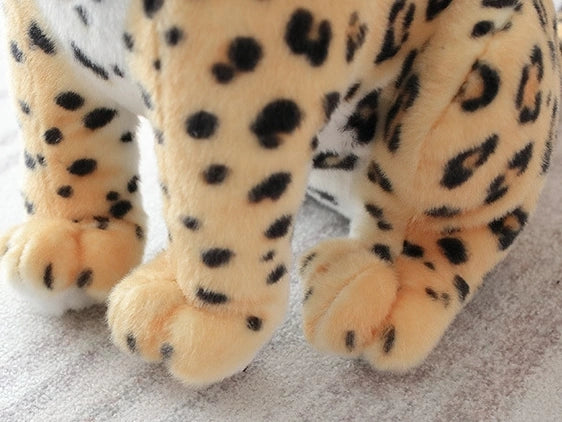 Close-up of ZoDoll's Cheetah Plush Animal Stuffed Toy (23cm/27cm/33cm), highlighting its soft, realistic yellow and black spotted legs and paws on a light surface.