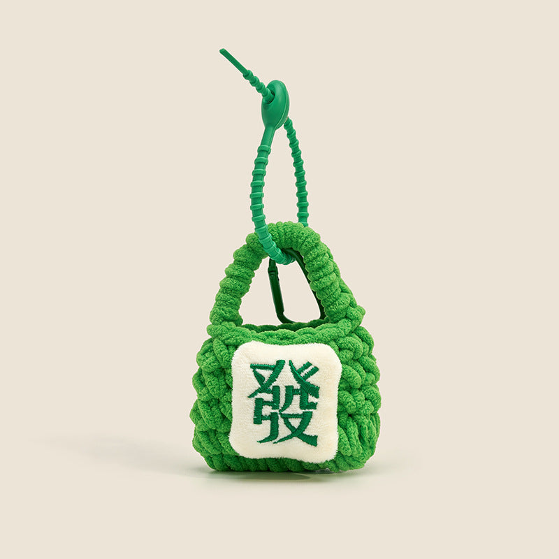 Green chunky-knit mini bag charm with white embroidered mahjong Fa prosperity tile patch and coiled green lanyard