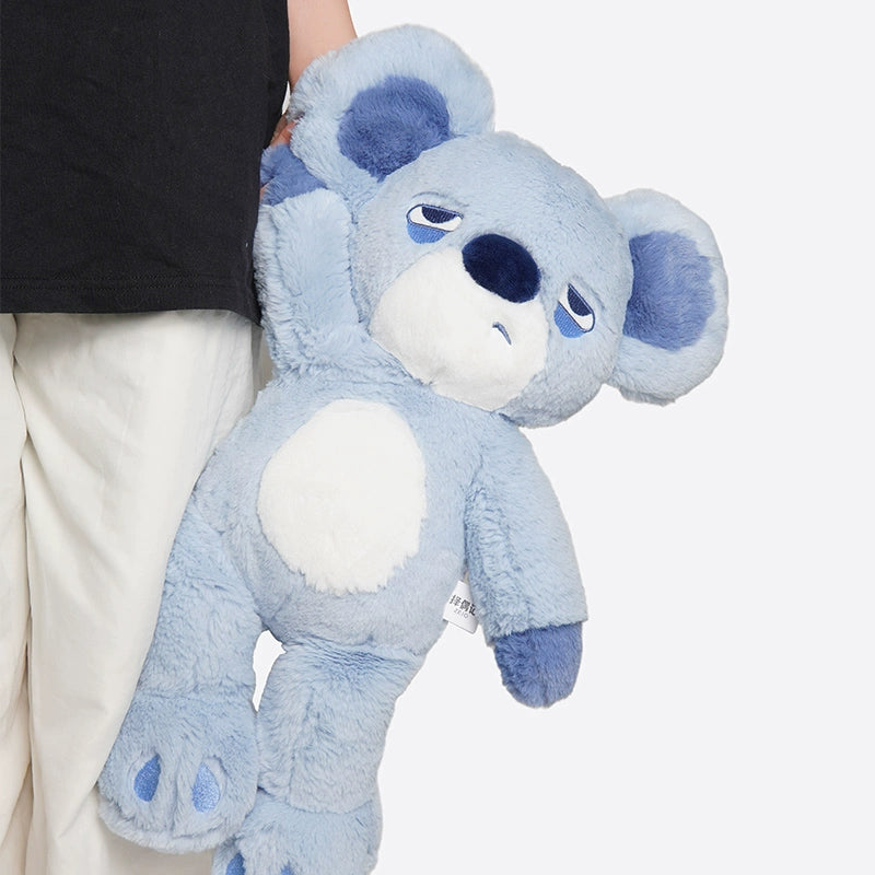 A person in white pants and a black shirt holds the ZEIO Koala Plush Toy 38cm—a soft, large stuffed koala with a relaxed expression—perfect for cuddling or as a charming nursery décor piece.