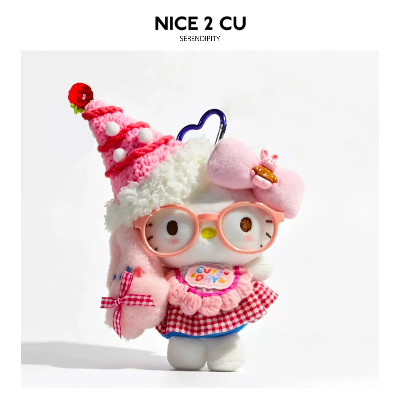 Kawaii cat plush bag charm wearing a pink strawberry cake hat, round pink glasses, and pink checkered outfit