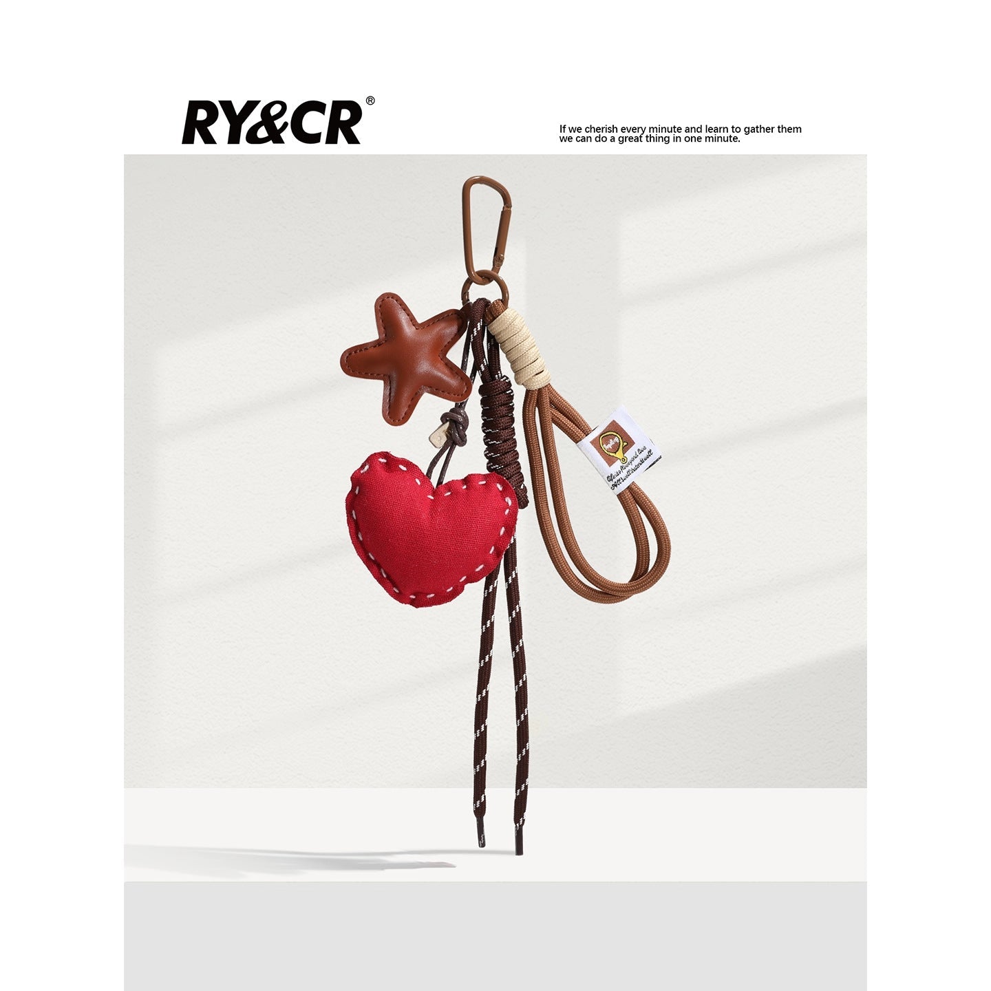 Red heart-shaped fabric charm with tan star accent on brown braided lanyard and carabiner clip
