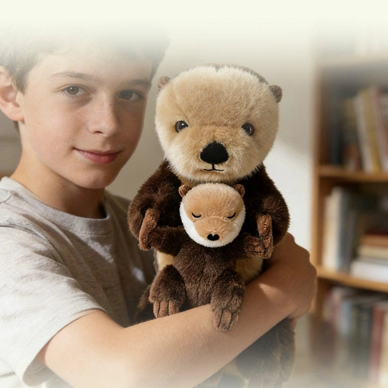 A boy stands indoors near a bookshelf holding the ZoDoll Otter Plush Toy Soft Sea Otter Stuffed Animal (40x12cm), which hugs a removable crab or baby.