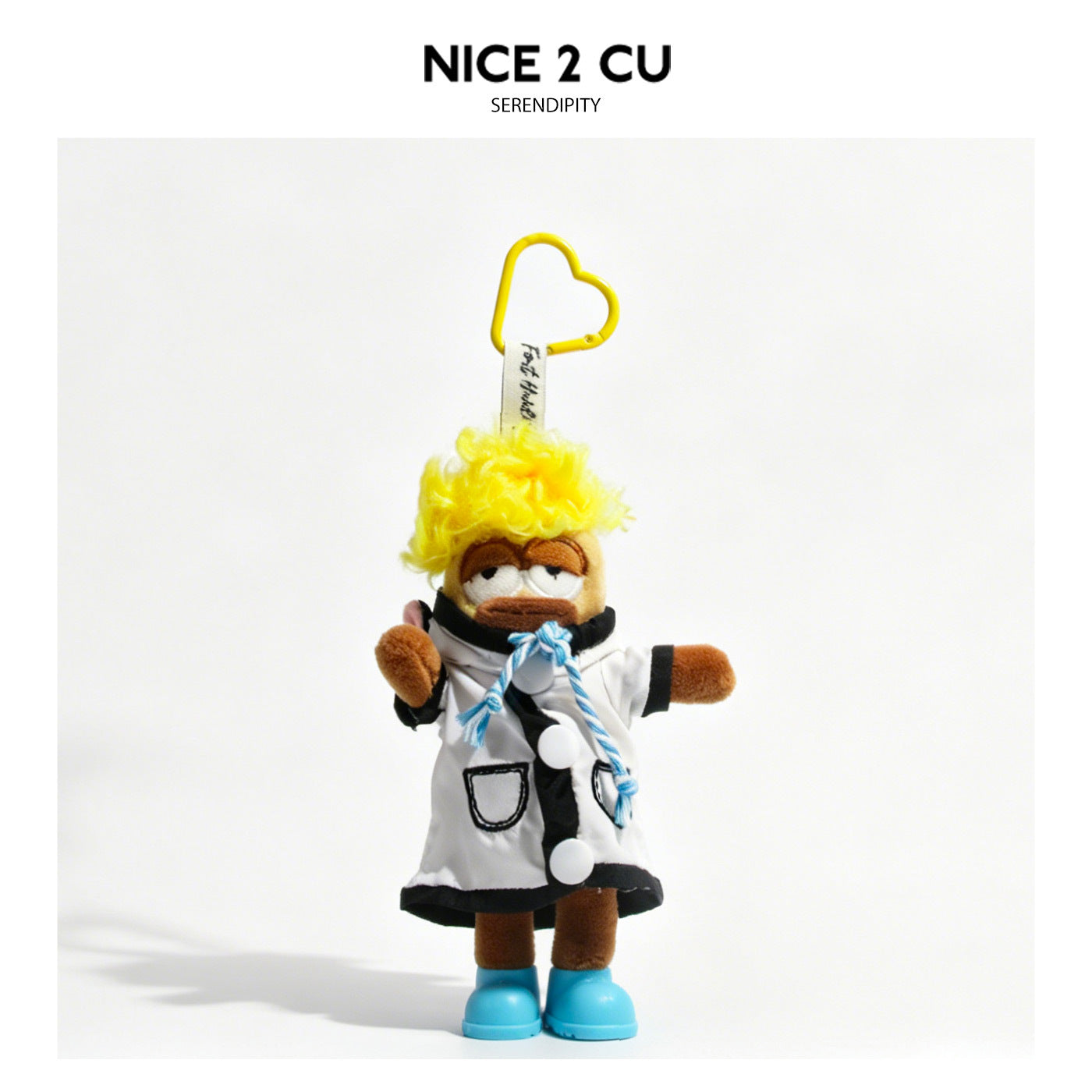 Khaki cartoon plush keychain in white coat with black accents, rope tie, and blue shoes attached to yellow heart-shaped carab