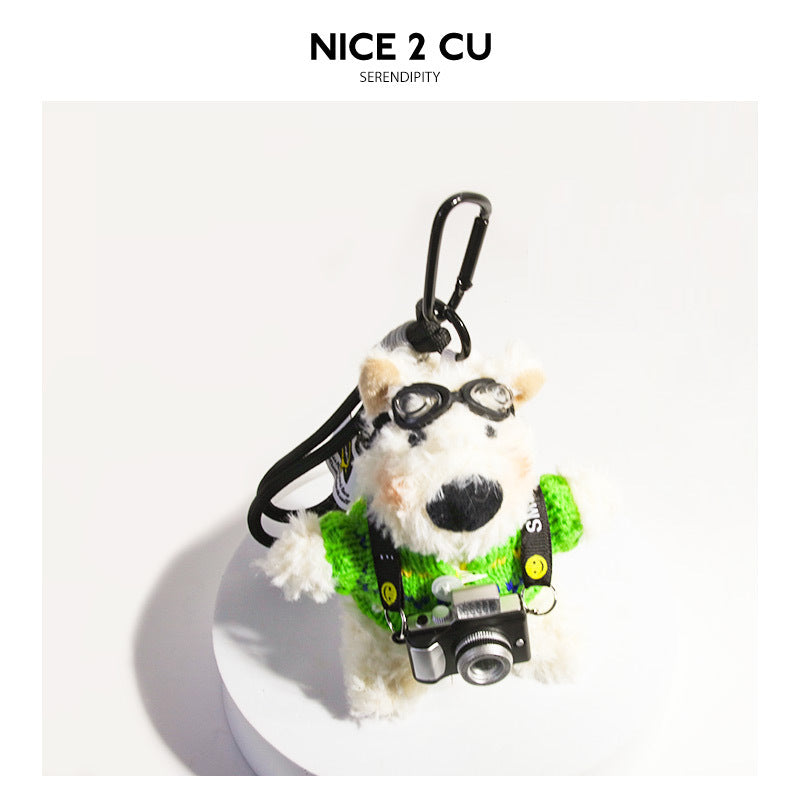 White plush terrier keychain charm in a bright green sweater with black goggles and a tiny camera accessory