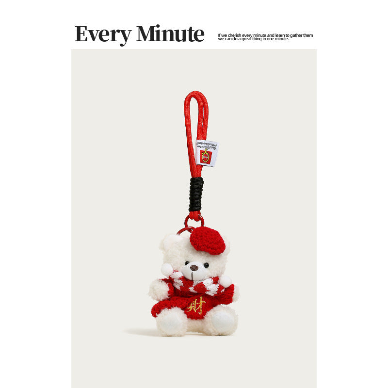 White plush teddy bear charm wearing red beret, striped scarf, and red sweater with gold prosperity character, red loop strap