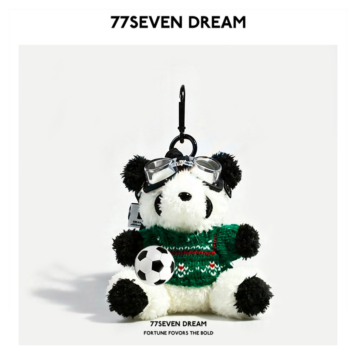 Panda plush charm wearing a green-and-white patterned knit sweater, goggles on forehead, holding soccer ball