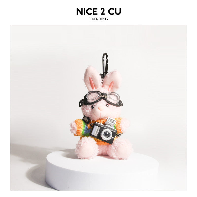 Pink plush rabbit keychain in rainbow-striped knit sweater with goggles and camera charm