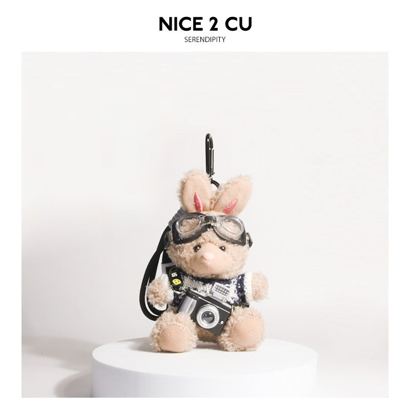 Brown plush rabbit keychain wearing blue-and-black knit sweater with goggles and miniature camera