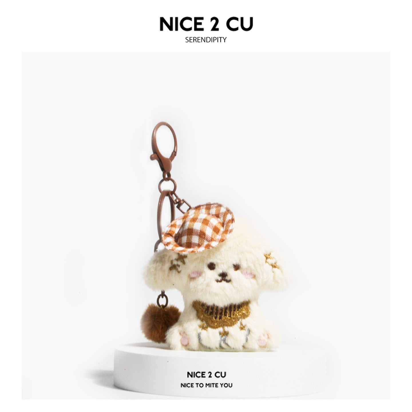 Cream plush dog keychain charm with brown checkered cap, gold embroidered chest detail, and brown pom-pom accent