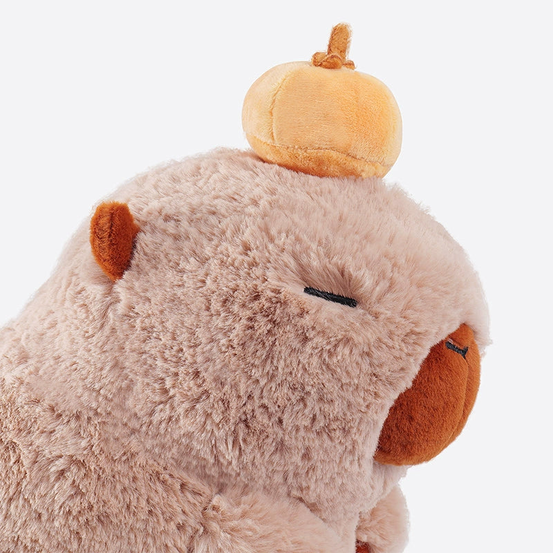 The ZEIO Capybara Plush Toy 25cm is a soft, light brown stuffed animal with closed eyes, an orange nose, and a cute pumpkin-shaped beret, shown against a plain background.