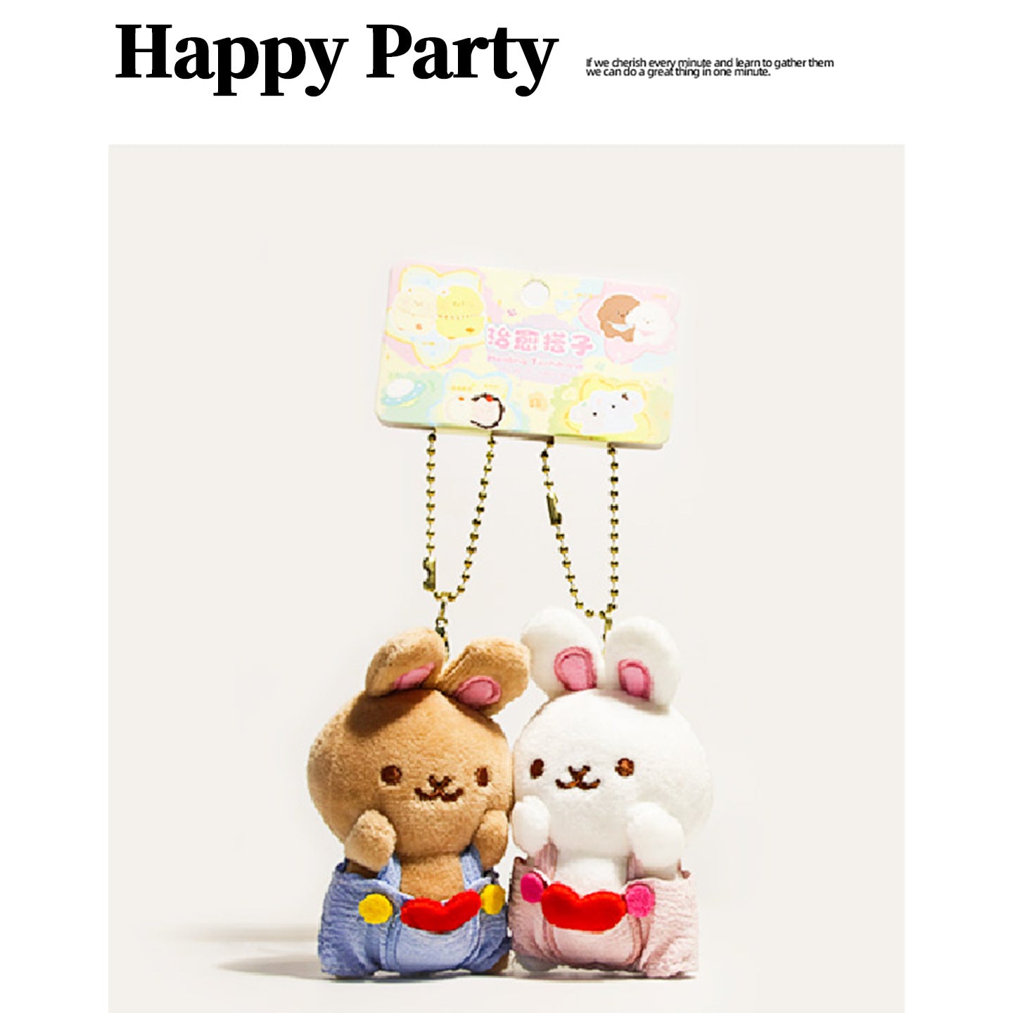 Pair of kawaii plush rabbit charms — tan bunny in blue overalls and white bunny in pink, sharing a red heart on gold ball cha