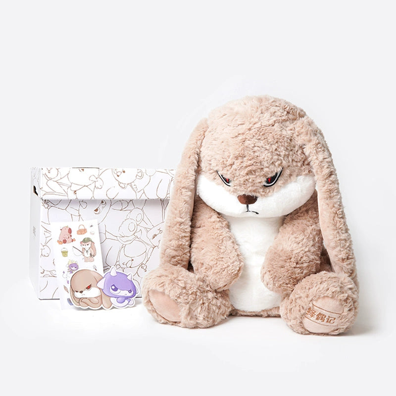 The ZEIO Bunny Plush Toy 38cm, a soft floppy-eared rabbit stuffed animal, sits beside a decorated box and two small character stickers on a white background—ideal for nursery décor.