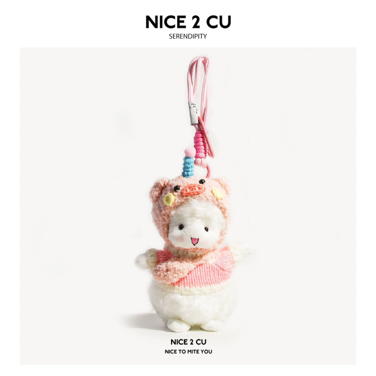 White lamb plush keychain wearing a pink pig costume hood and pink knitted sweater with coiled cord clip
