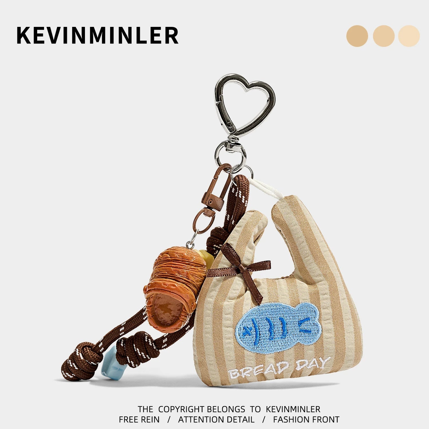Brown and beige striped mini tote bag charm with blue embroidered motif, slipper accent charm, and silver heart carabiner cli