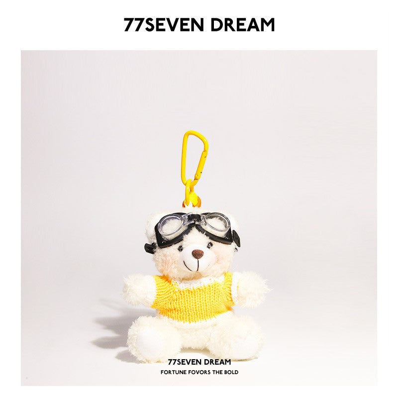 White bear plush keychain wearing yellow-and-white knit sweater and goggles with yellow hanging clip