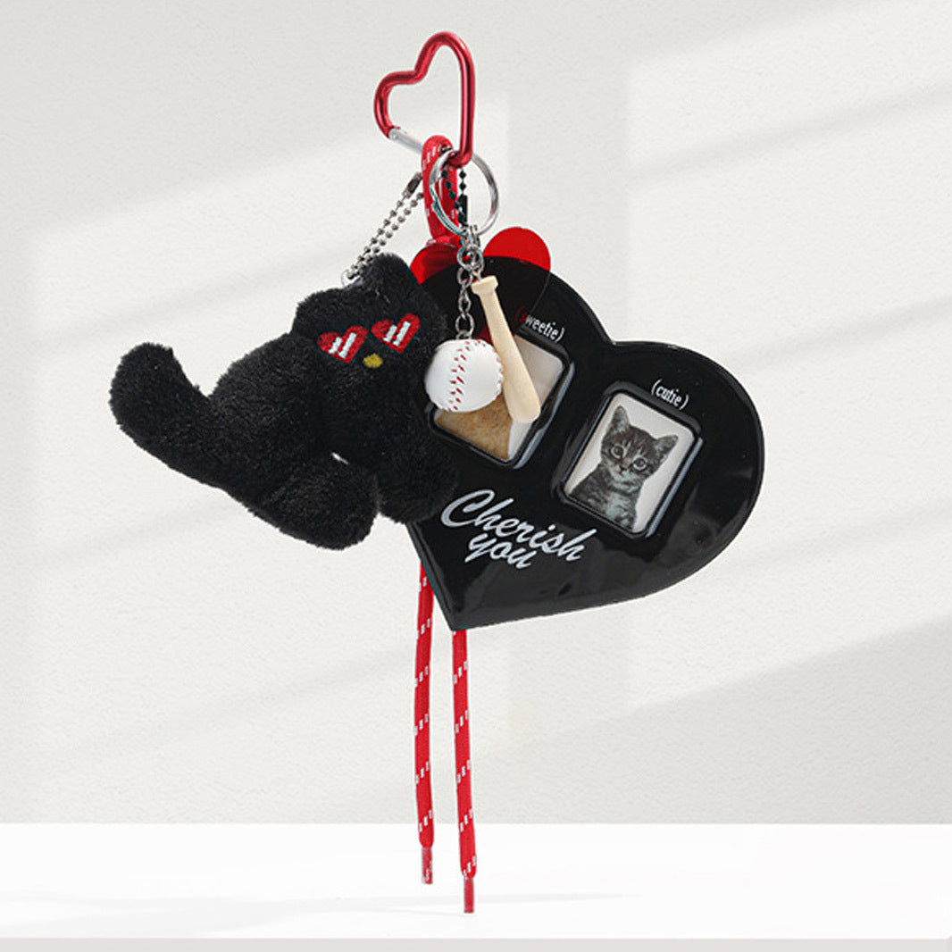 Black heart photo card holder bag charm with black cat plush figure, red ribbon accents, and silver heart hook