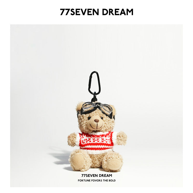 Beige teddy bear plush keychain wearing a red-and-white striped knit sweater with aviator goggles
