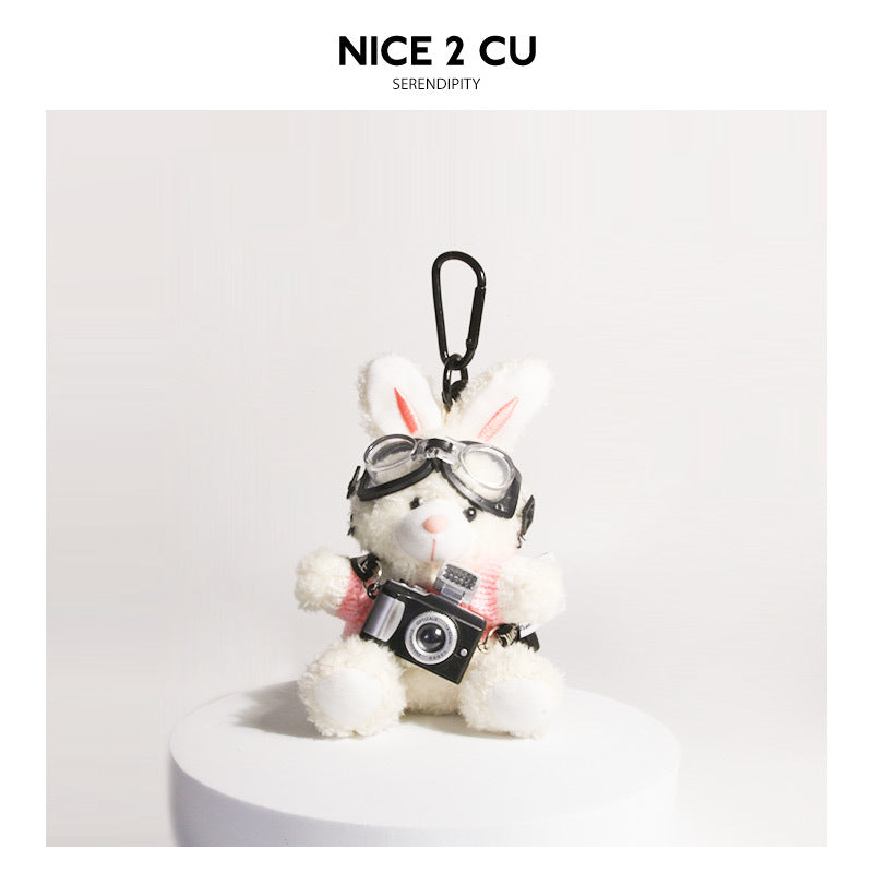 White plush rabbit keychain in pink-and-white knit sweater with goggles and small camera charm