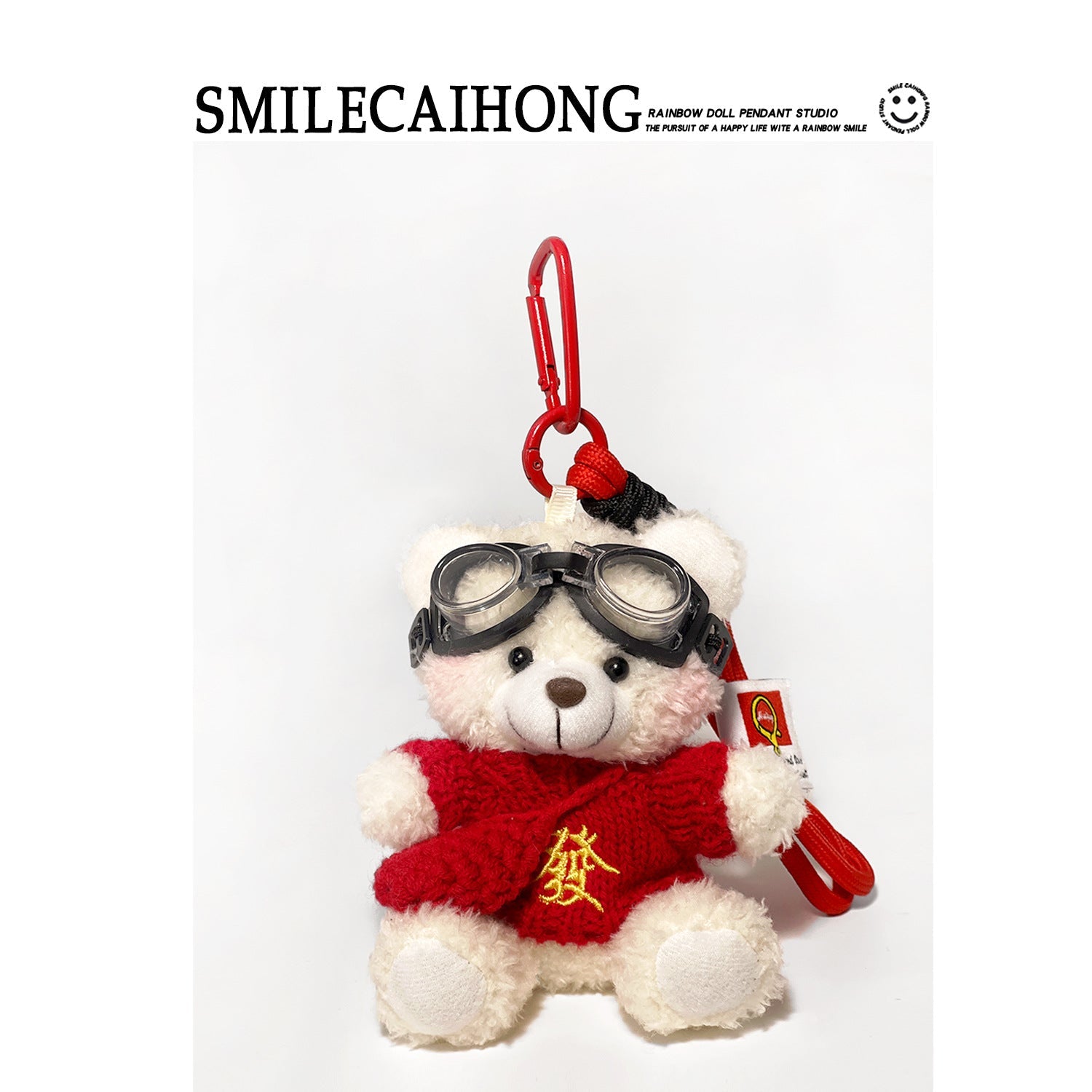 White plush teddy bear keychain wearing red robe with gold 發 character and aviator goggles, red carabiner clip