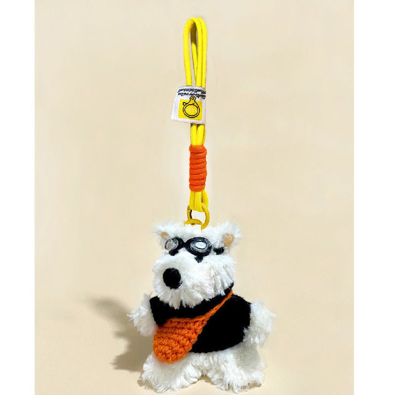 White terrier plush charm with goggles, black jacket, orange knitted bag, and yellow braided clip cord