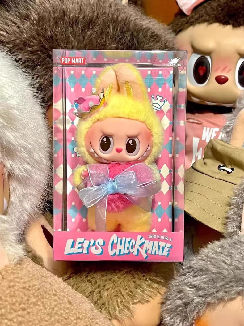 The POP MART Labubu Let's Checkmate Series – Pink Heart Bunny Plush Vinyl Doll features Labubu in a yellow and pink bunny suit with a blue ribbon—an adorable collectible for designer toy fans.