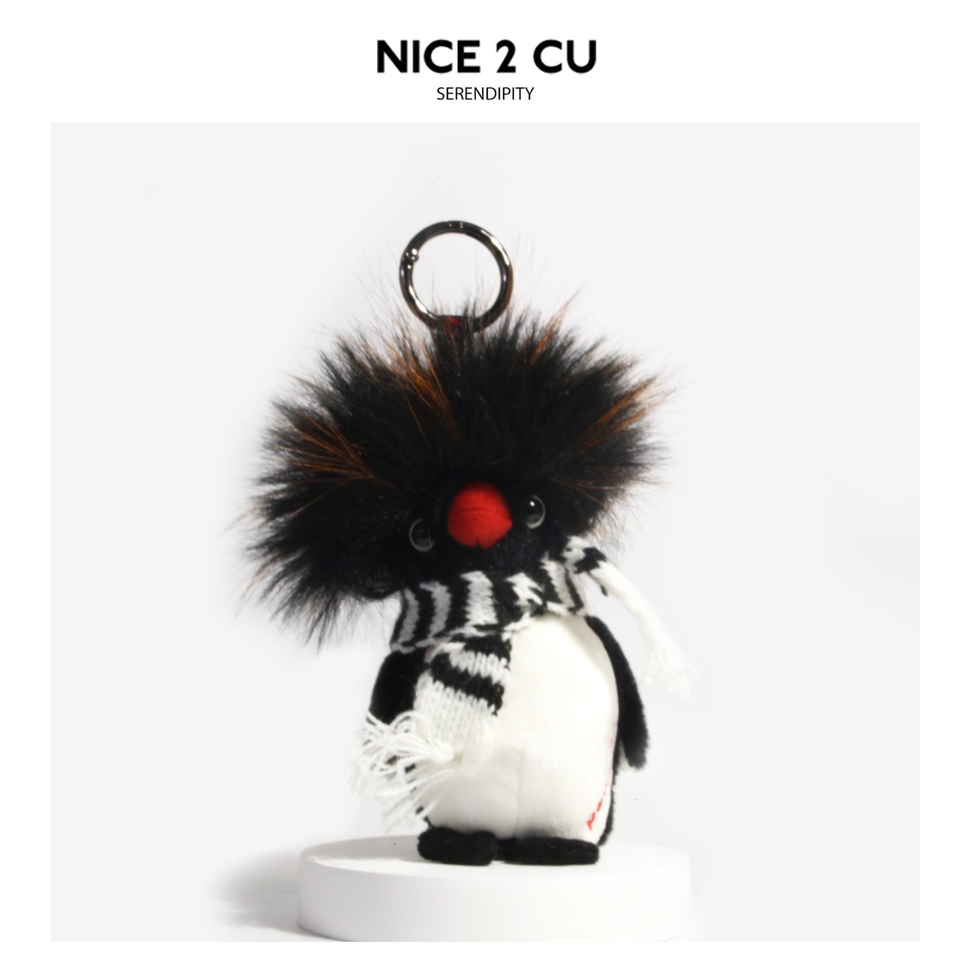 Fluffy penguin plush charm with black-and-white striped fringed scarf and metal hanging loop