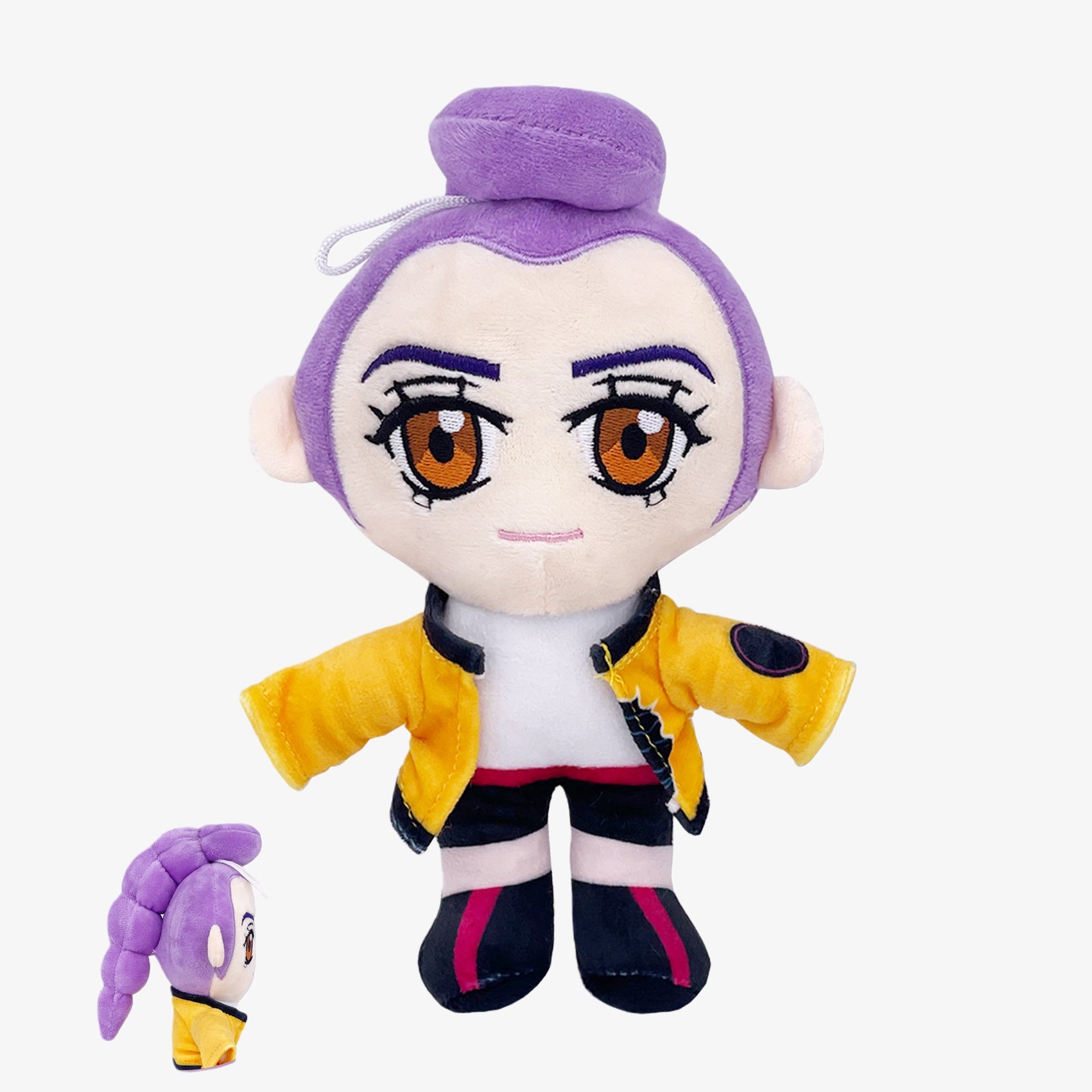 The Demon Hunters Anime Plush Doll is a 9-inch soft stuffed toy of a purple-haired female character with large brown eyes, a yellow jacket, black shorts, pink shoes, and a hanging loop. Side view shown bottom left.