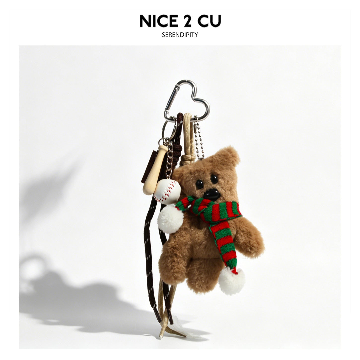 Plush brown teddy bear bag charm with red-green striped scarf, heart carabiner clip, and miniature baseball and bat charms