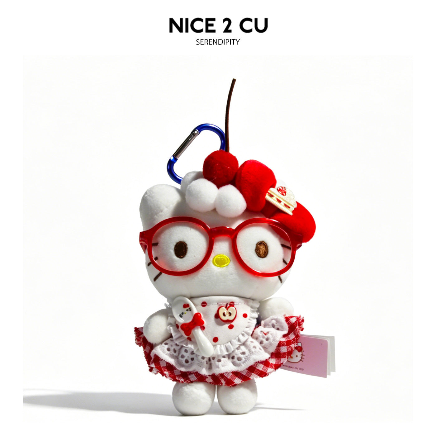 Kawaii cat plush charm with red glasses, red checkered skirt, and dessert-themed decorations
