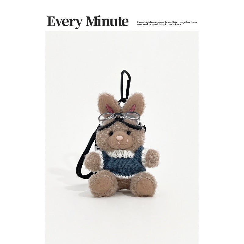 Brown rabbit plush keychain charm wearing aviator goggles and a blue-and-white knit sweater with black carabiner clip
