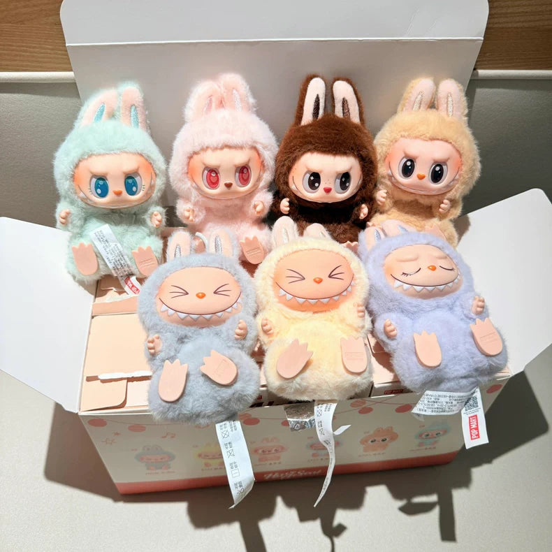 Six Labubu Have a Seat Series plush keychains by POP MART from The Monsters are displayed in and around an open pastel box; the complete 6-piece set contains no duplicates and features animal-themed designs with large eyes.