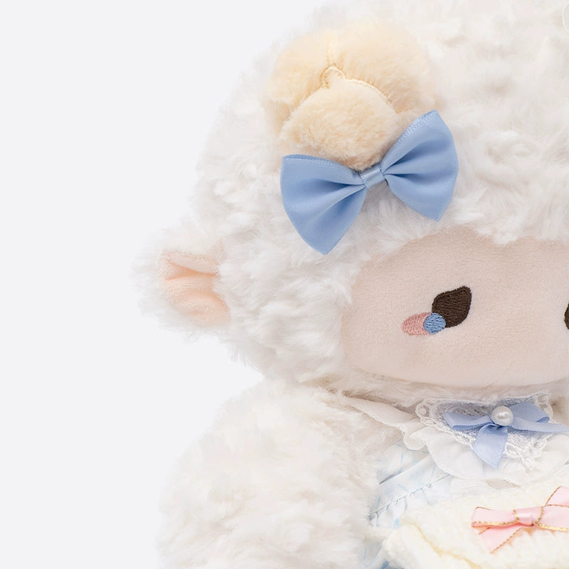 The ZEIO Dressed Lamb Plush Toy (29cm) features soft white fur, a blue bow, and a stylish blue outfit—chest-up view against a plain background—ideal as a collectible or for nursery décor.