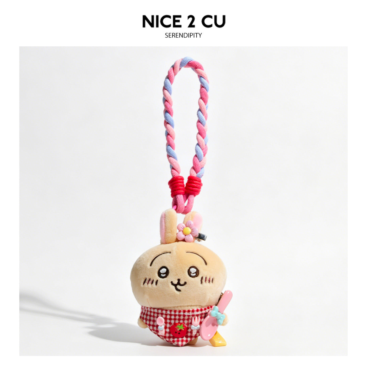 Kawaii cat plush bag charm wearing a red checkered bib apron with braided pink and blue loop lanyard