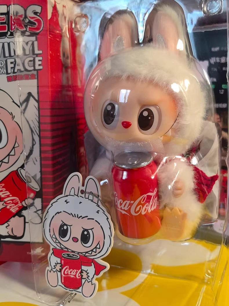 The Labubu Coca‑Cola Happy Factor Plush Keychain – White Bunny by POP MART comes in plastic packaging with a matching sticker and red box, making it a perfect collectible for POP MART or Coca-Cola fans.