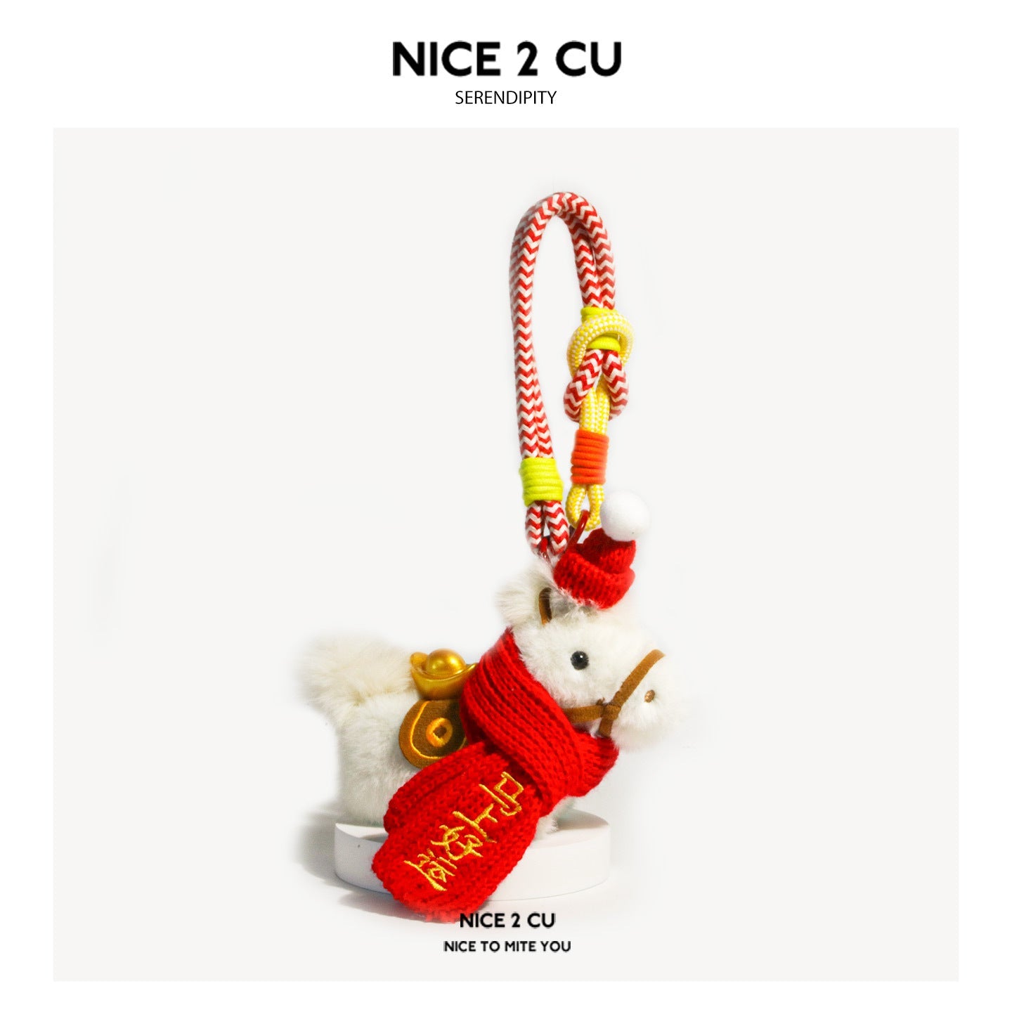 White plush horse charm in red knitted wrap with gold embroidered characters, red pompom hat, and braided red-white wrist-loo