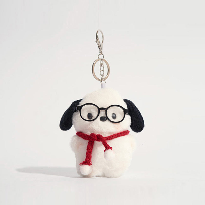 White plush dog keychain charm with black ears wearing black-framed glasses and a red scarf