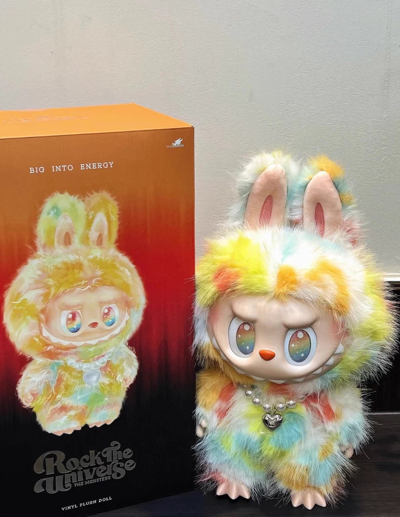 The Labubu Big into Energy Series Plush Doll (37cm) by POP MART, featuring bunny ears and a pearl necklace, stands next to its Rock the Universe-themed illustrated box from the designer collectible collection.