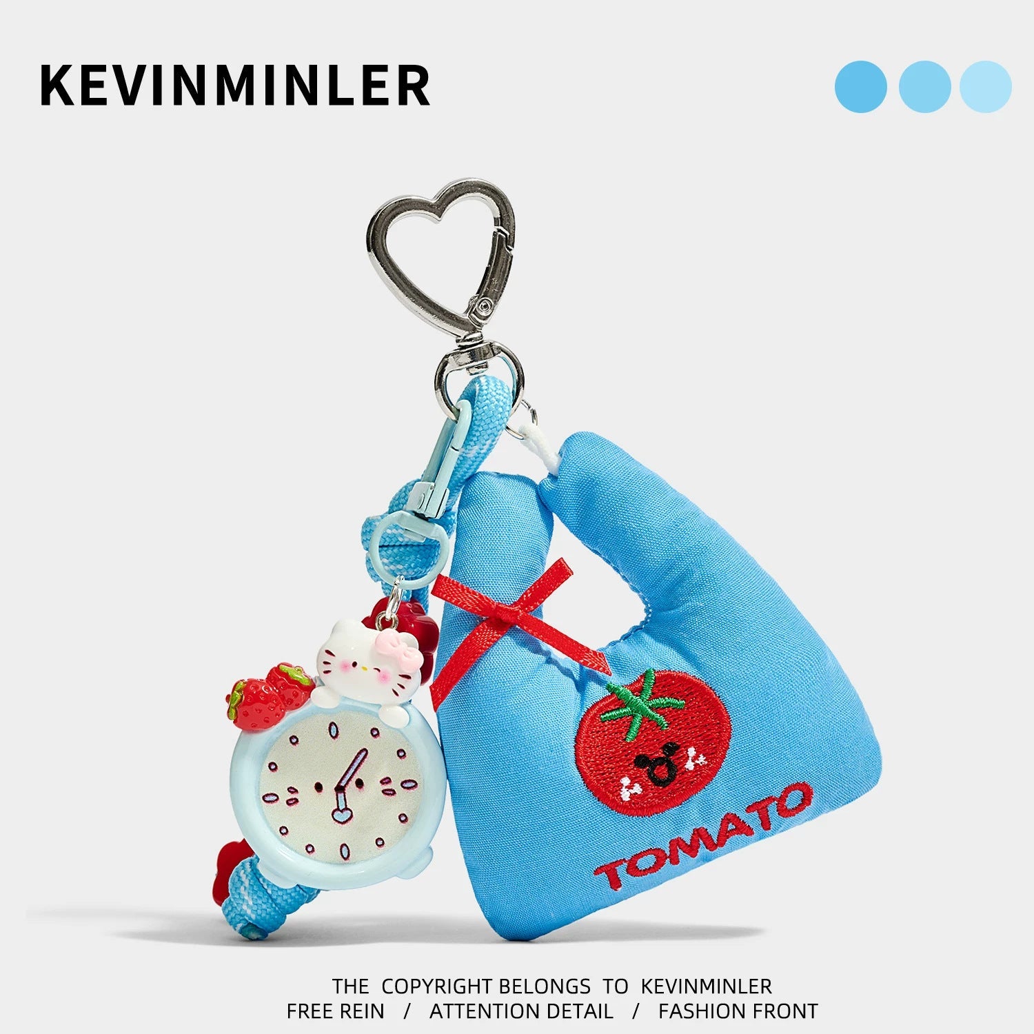 Blue fabric mini tote bag charm with embroidered tomato patch, red ribbon bow, alarm clock sub-charm, and silver heart carabi